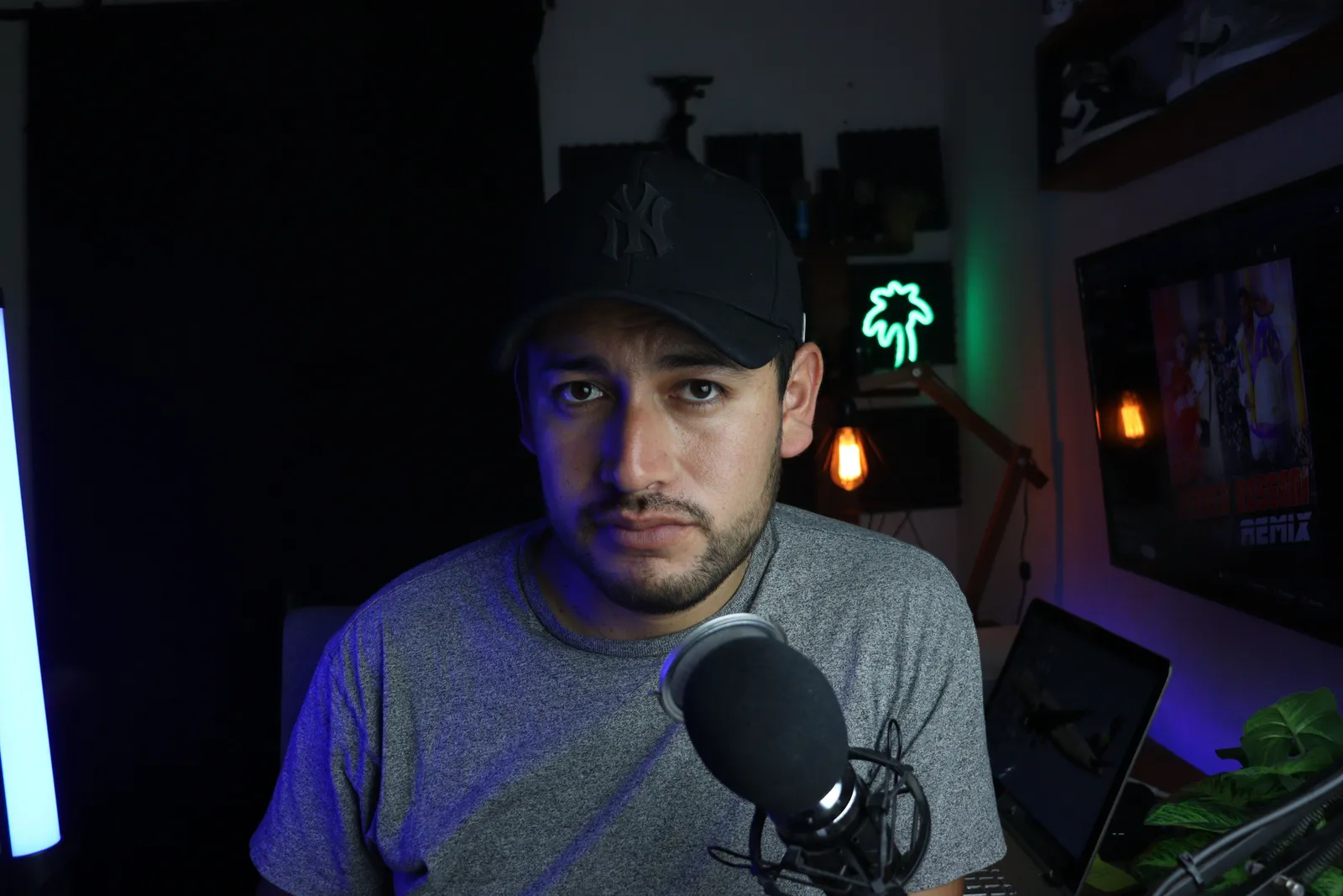 Male content creator in a home studio setup with microphone and soft lighting