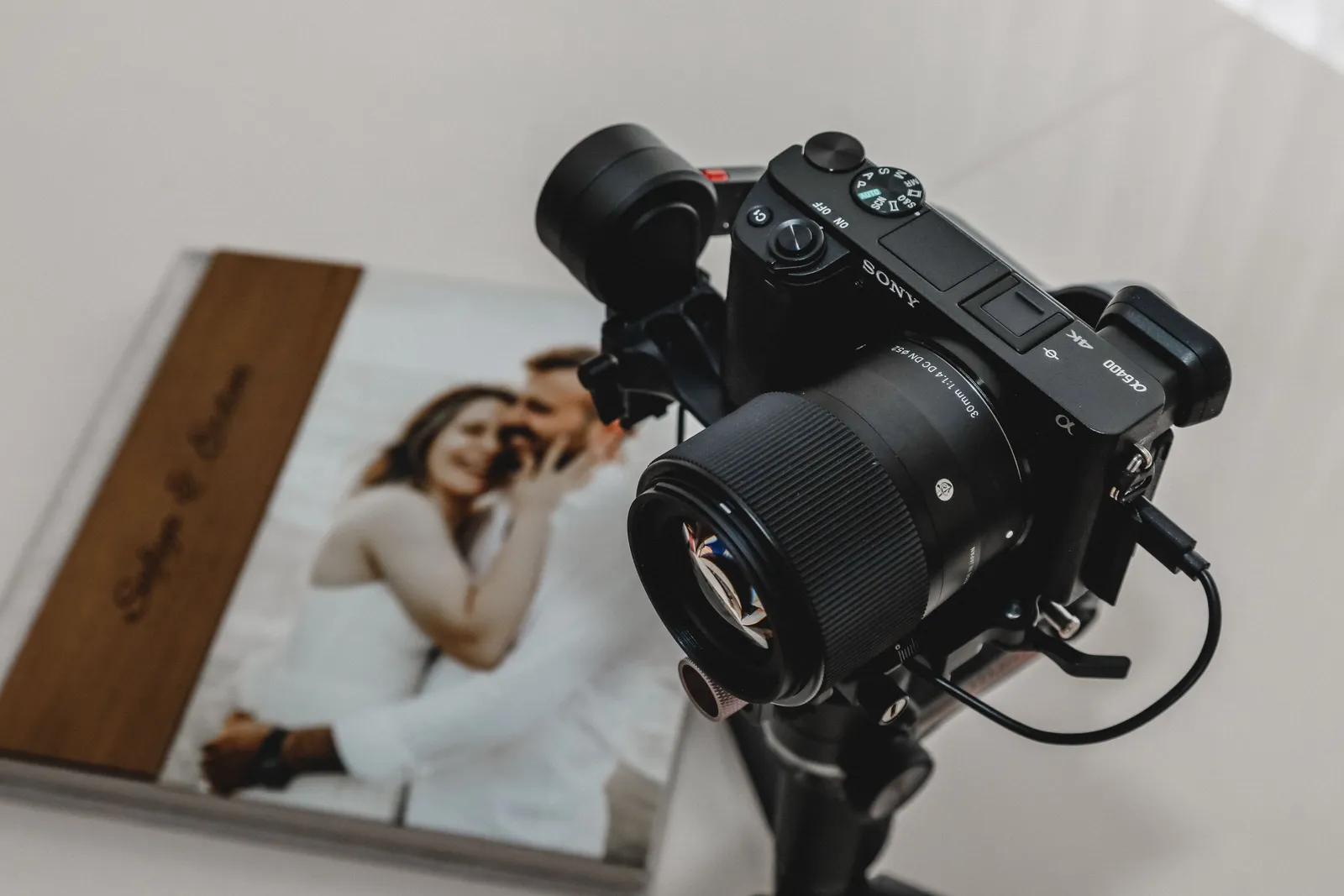 High-quality camera on tripod next to wedding photo album, ideal for photography shoots