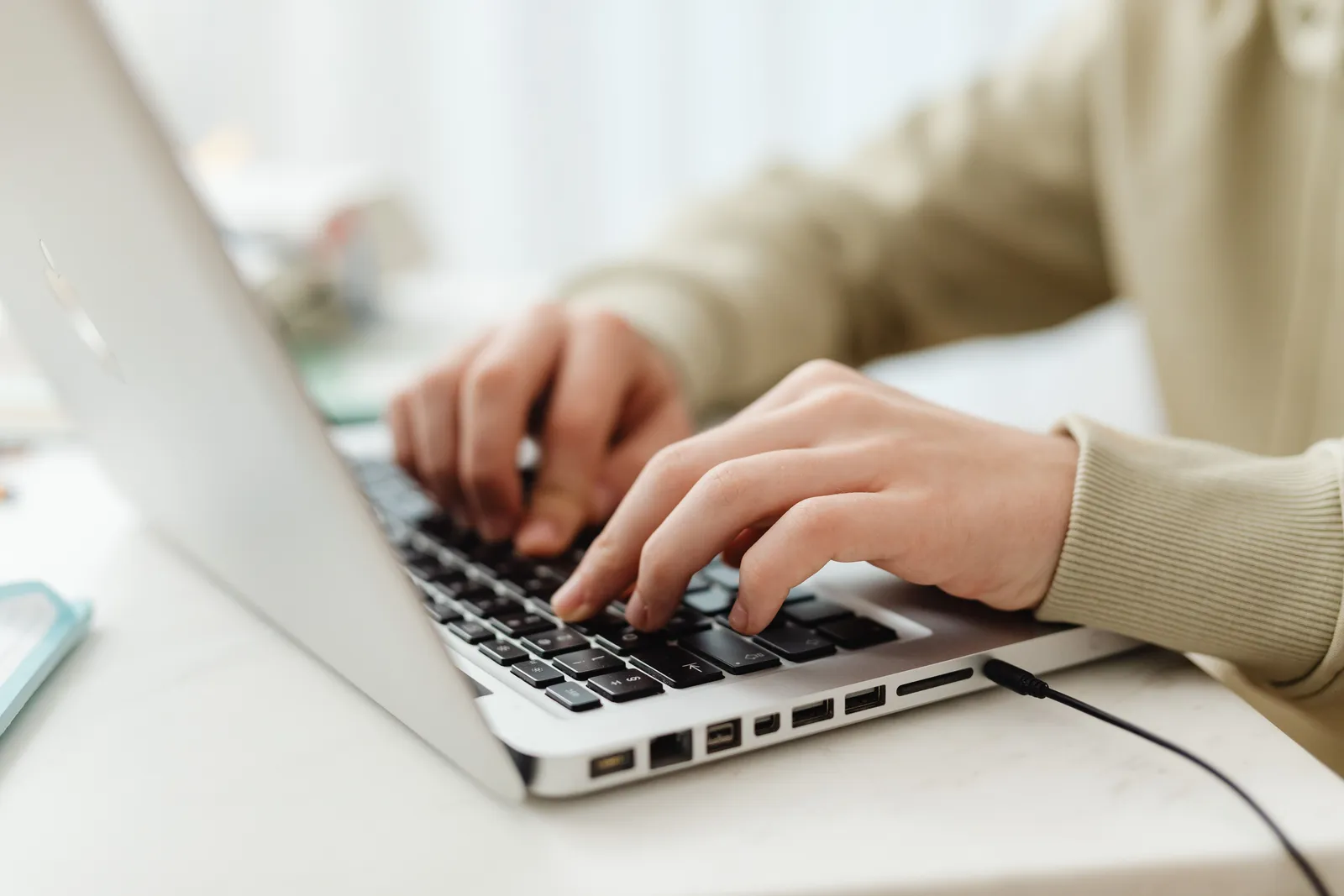 Close-up shot of hands typing on a laptop keyboard indoors, perfect for technology, business, and lifestyle themes