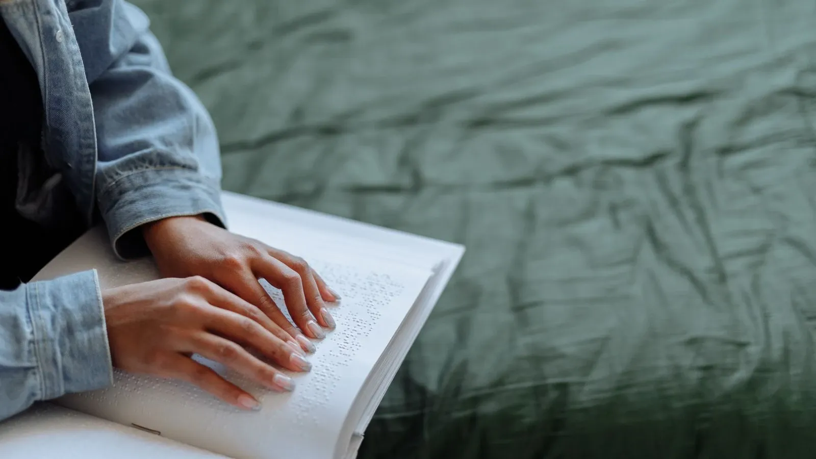 Hands reading raised Braille text