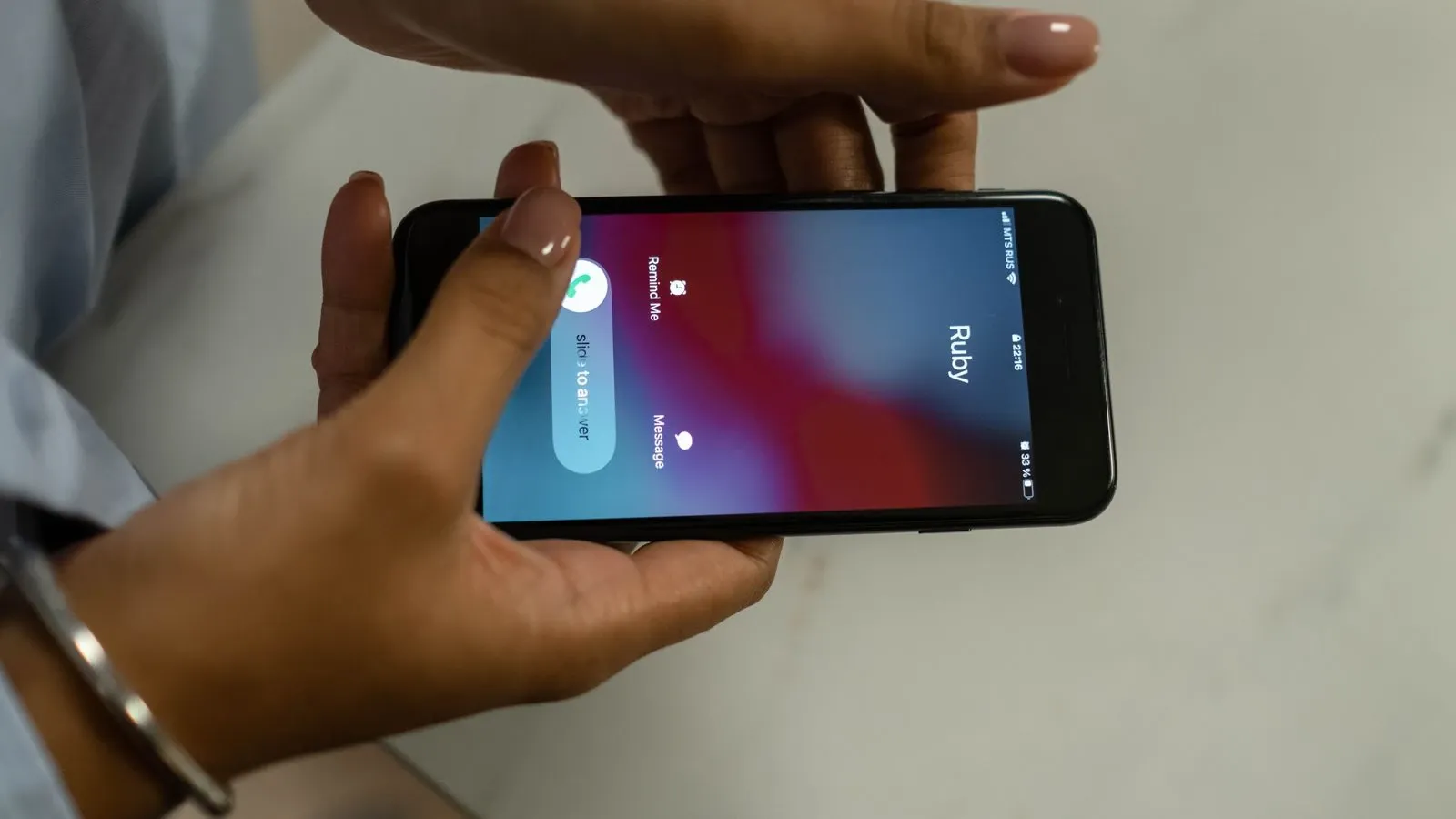 Hands holding a phone with an incoming call