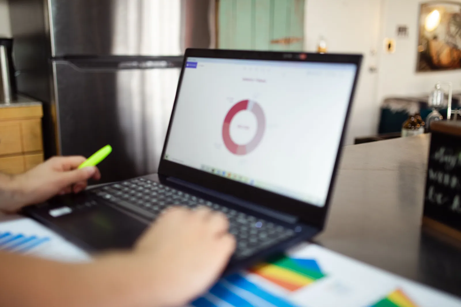Person analyzing business data on a laptop in a modern indoor setting