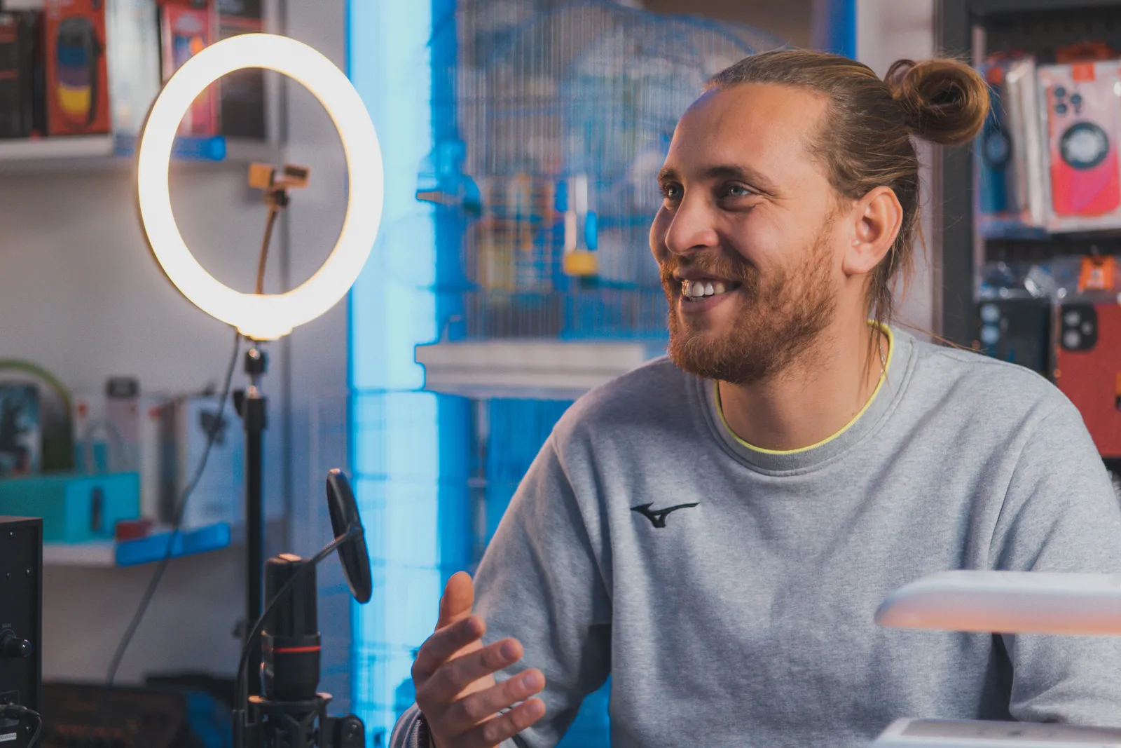 Smiling man with long hair recording content in a studio setting
