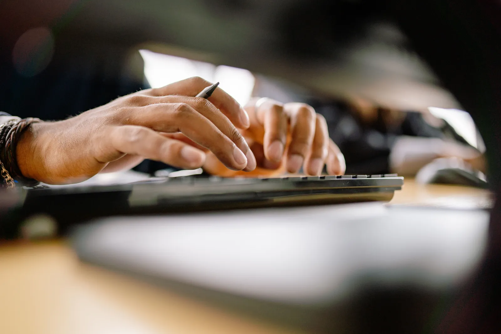 A detailed view of a person typing on a keyboard, emphasizing productivity and office work
