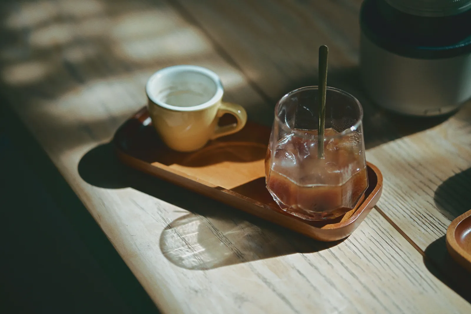 A cozy scene with a vintage coffee cup and iced drink on a wooden table
