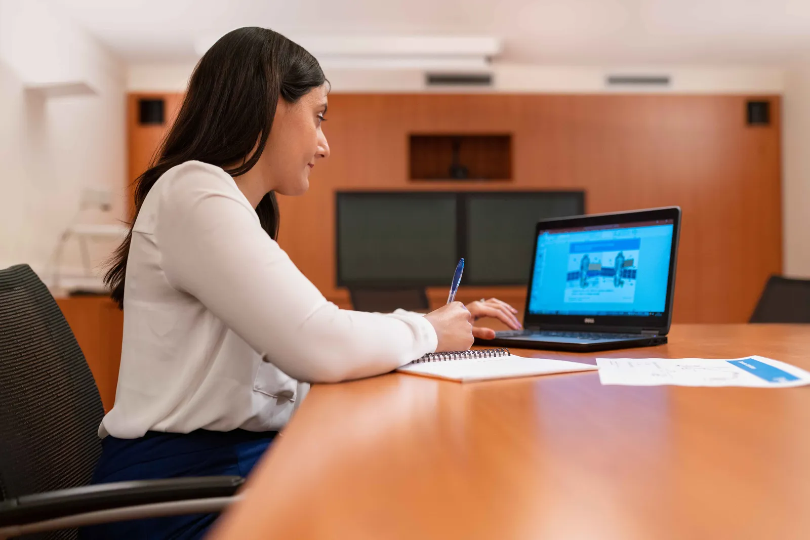 Professional woman working at a laptop in a modern office setting