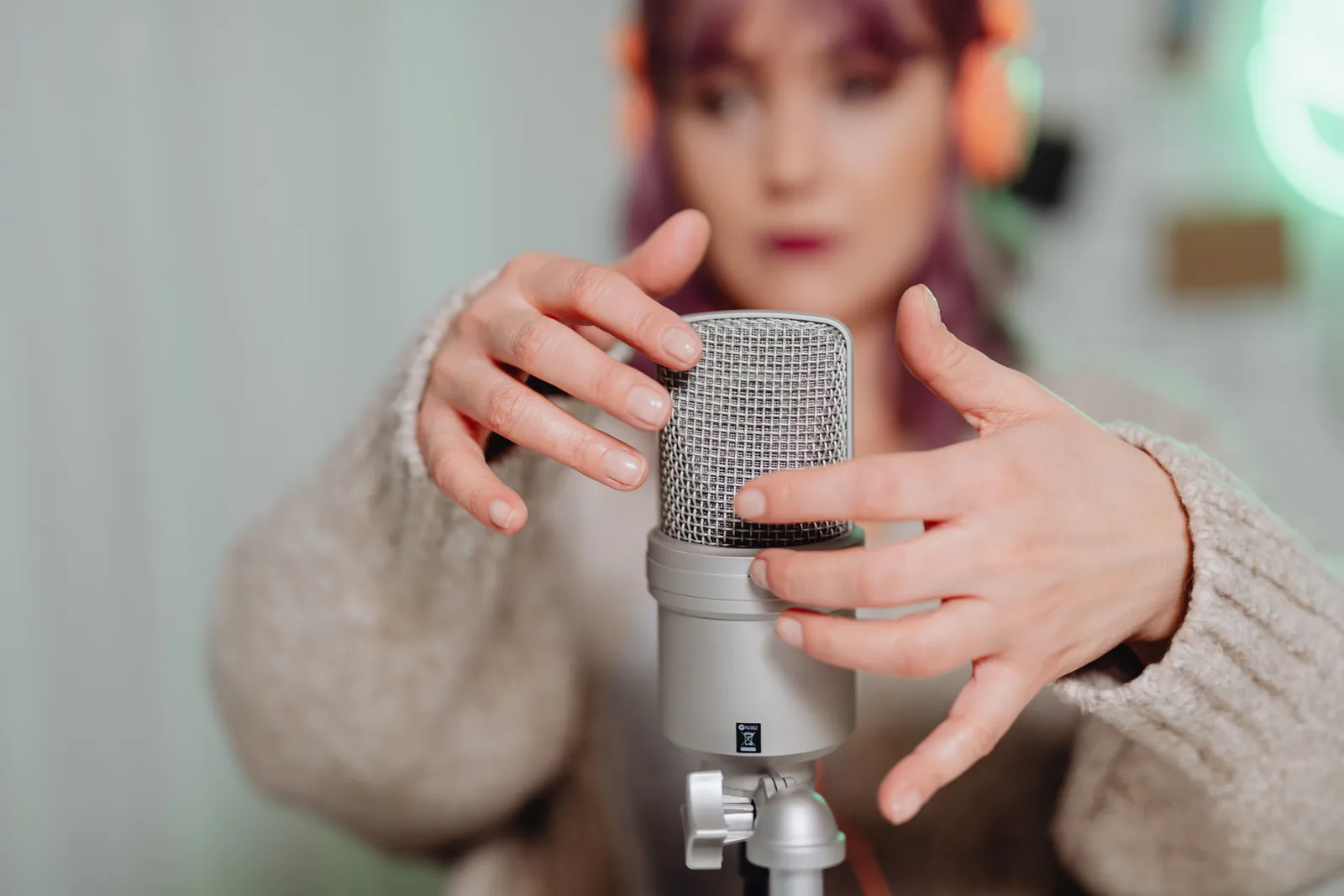 Woman recording ASMR using a microphone in a calm indoor setting