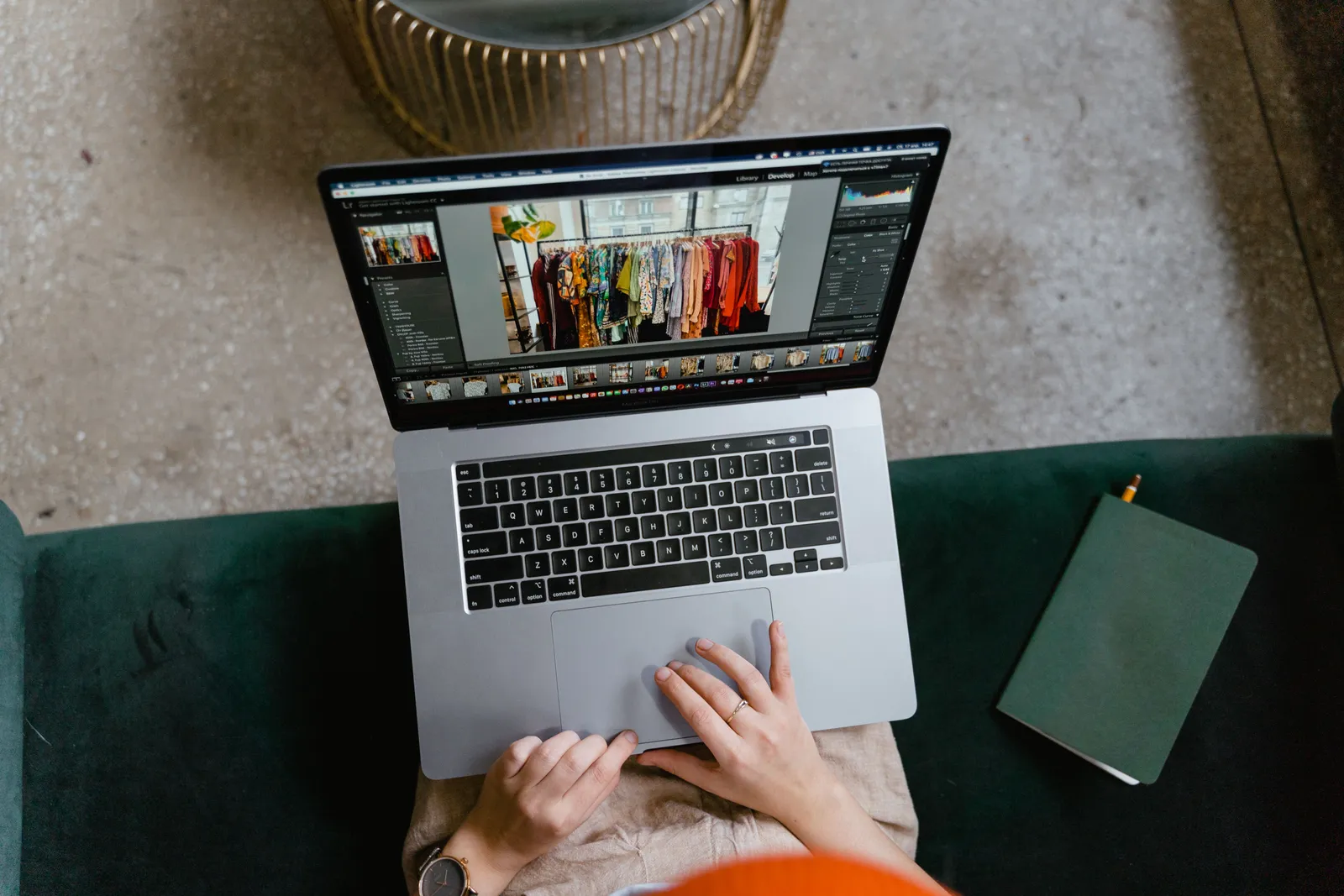 Person editing clothing photos on a laptop indoors, showcasing online fashion business or e-commerce work
