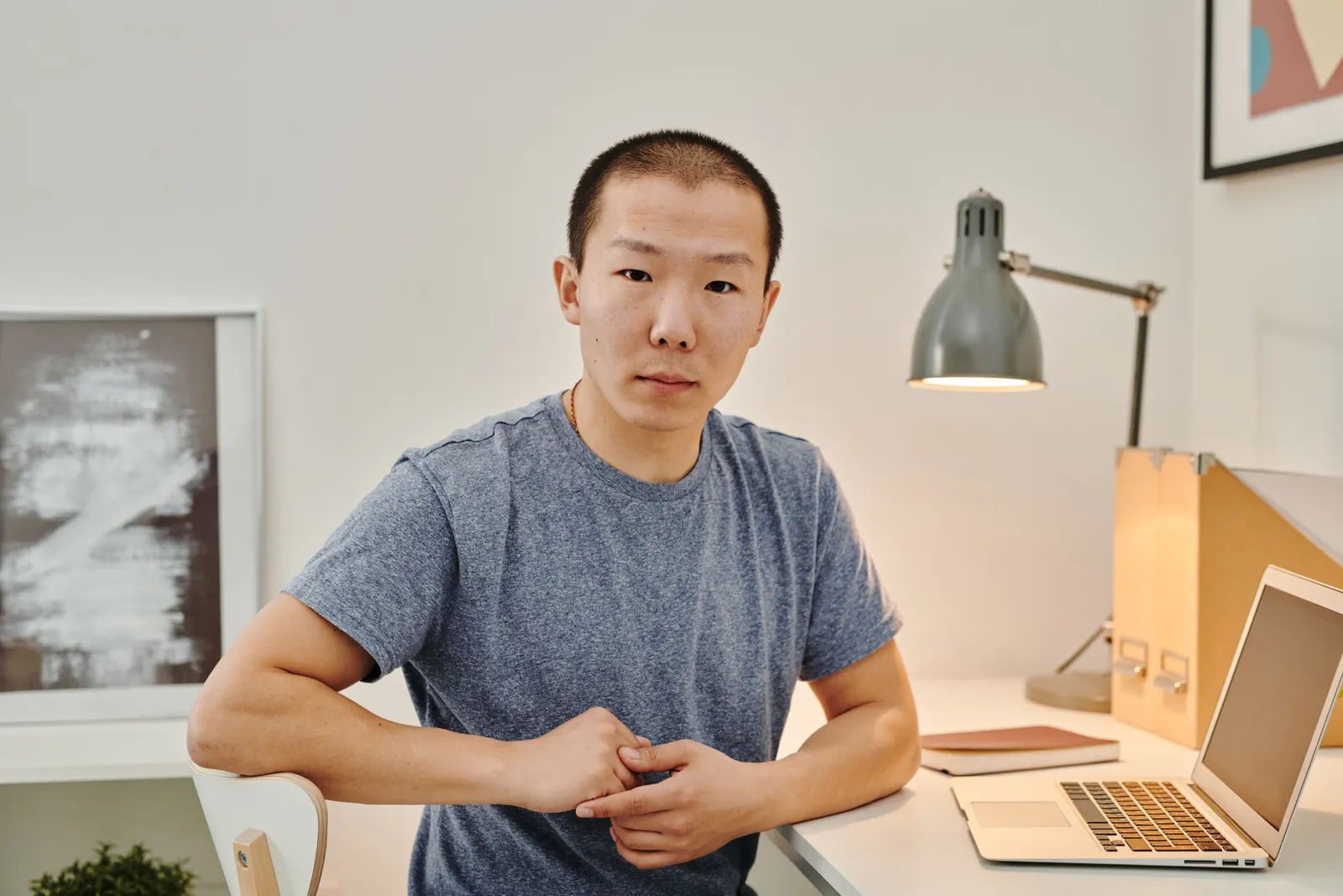 Man sitting at a desk with a laptop, engaged in remote work from a stylish home office