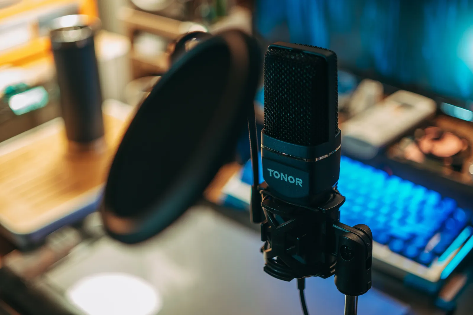 Close-up of a modern studio microphone with pop filter on a desk, perfect for recording