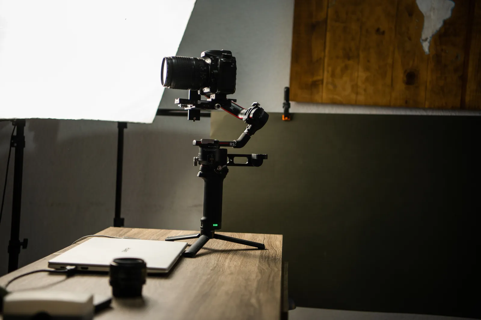 DSLR camera on gimbal setup in a well-lit photography studio with wooden accents