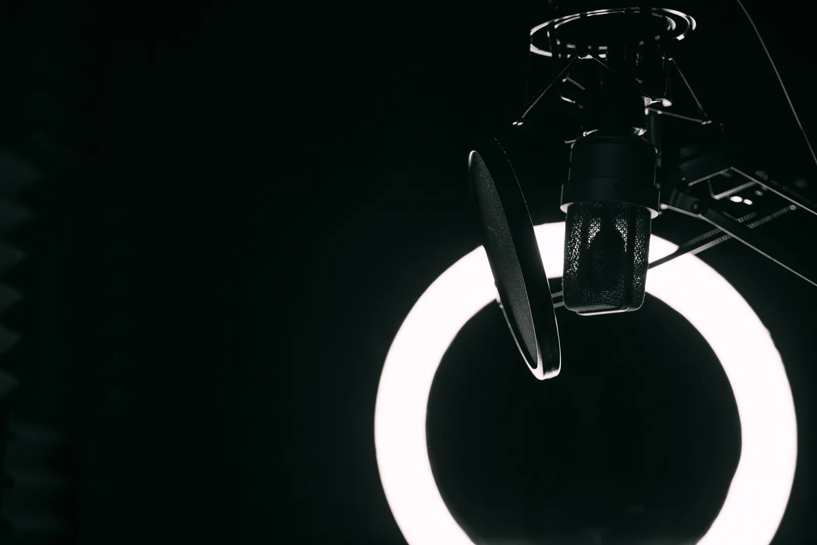 A close-up view of a microphone and ring light in a professional recording studio setting