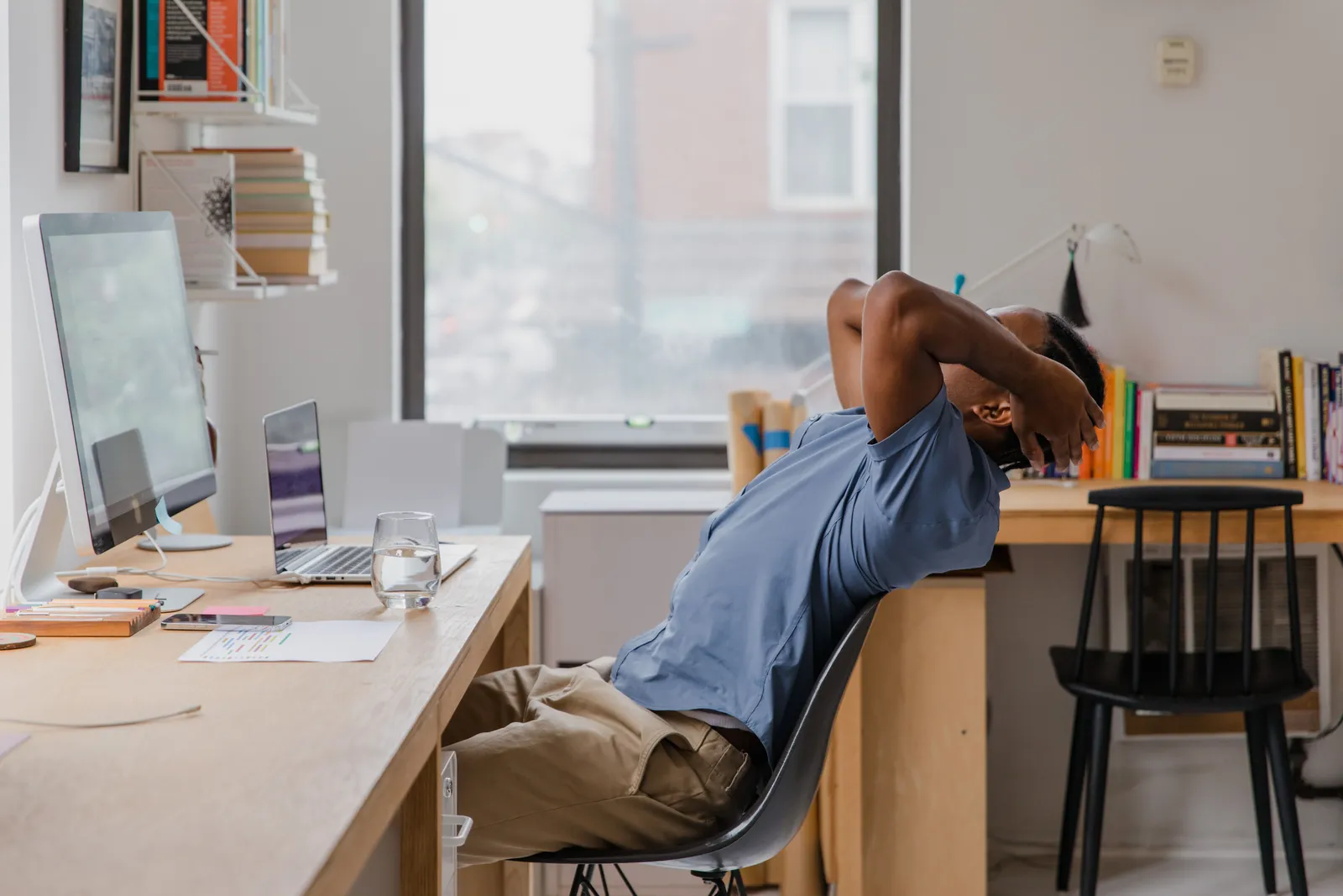 A man sits back in a chair at his home office, indicating a relaxing work environment