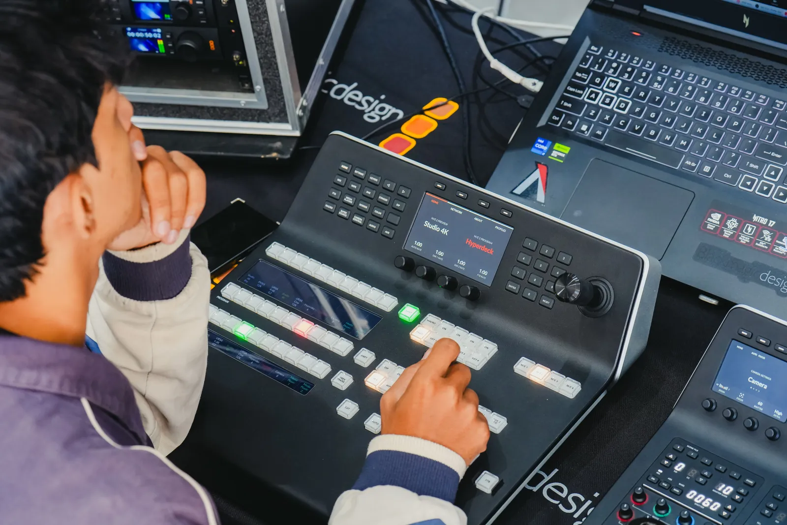 A man operating a video editing console in a high-tech studio setup