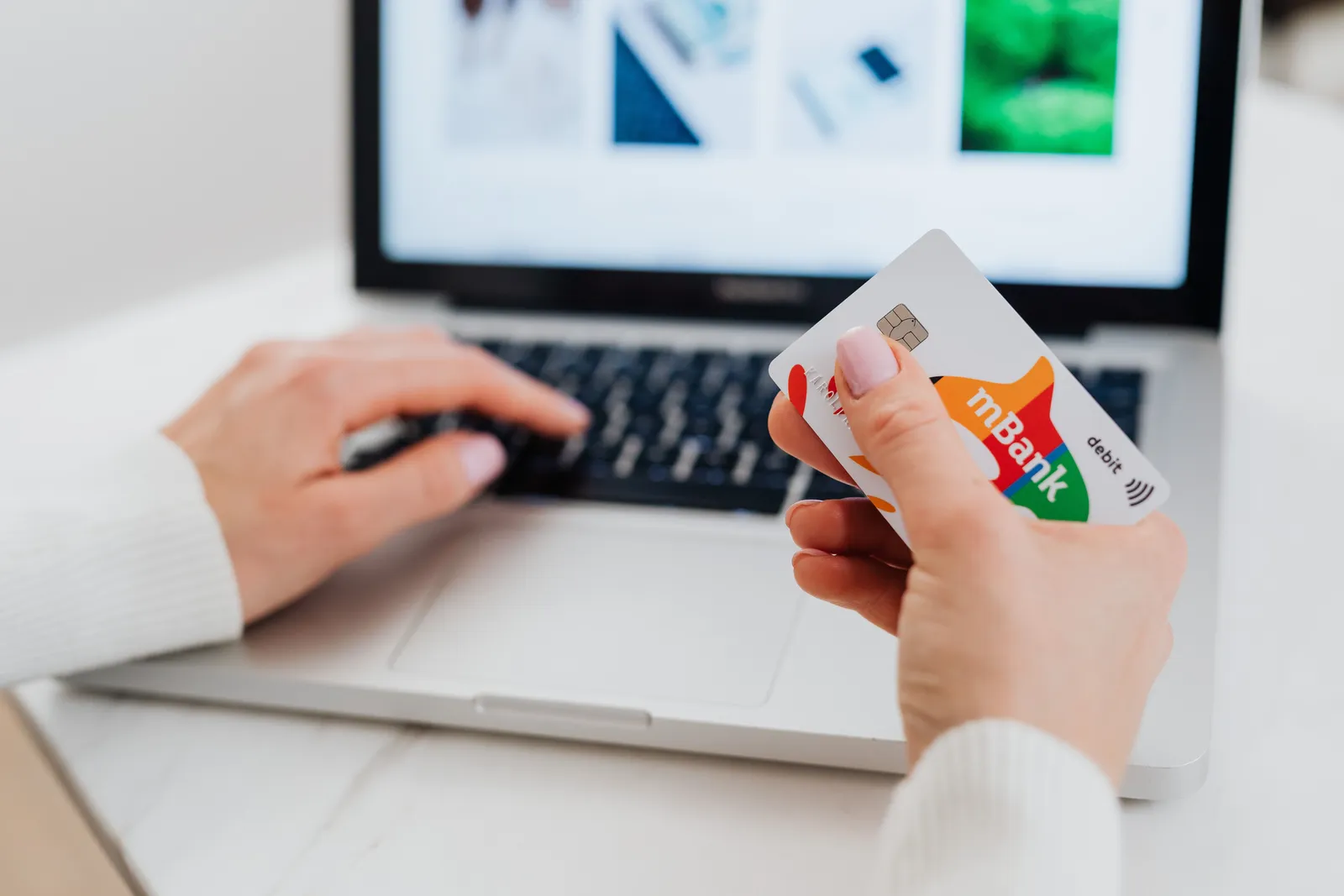 Close-up of hands using a laptop and holding a credit card for an online transaction