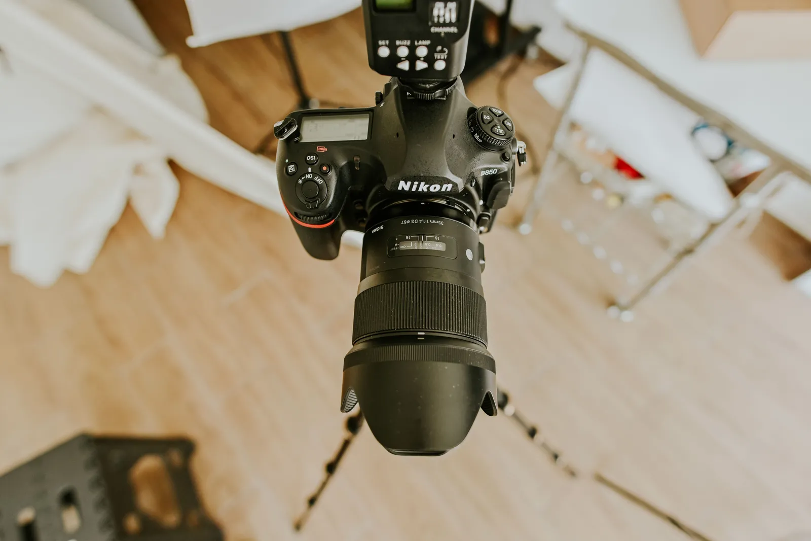 High-angle view of a DSLR setup with a long lens on a tripod indoors
