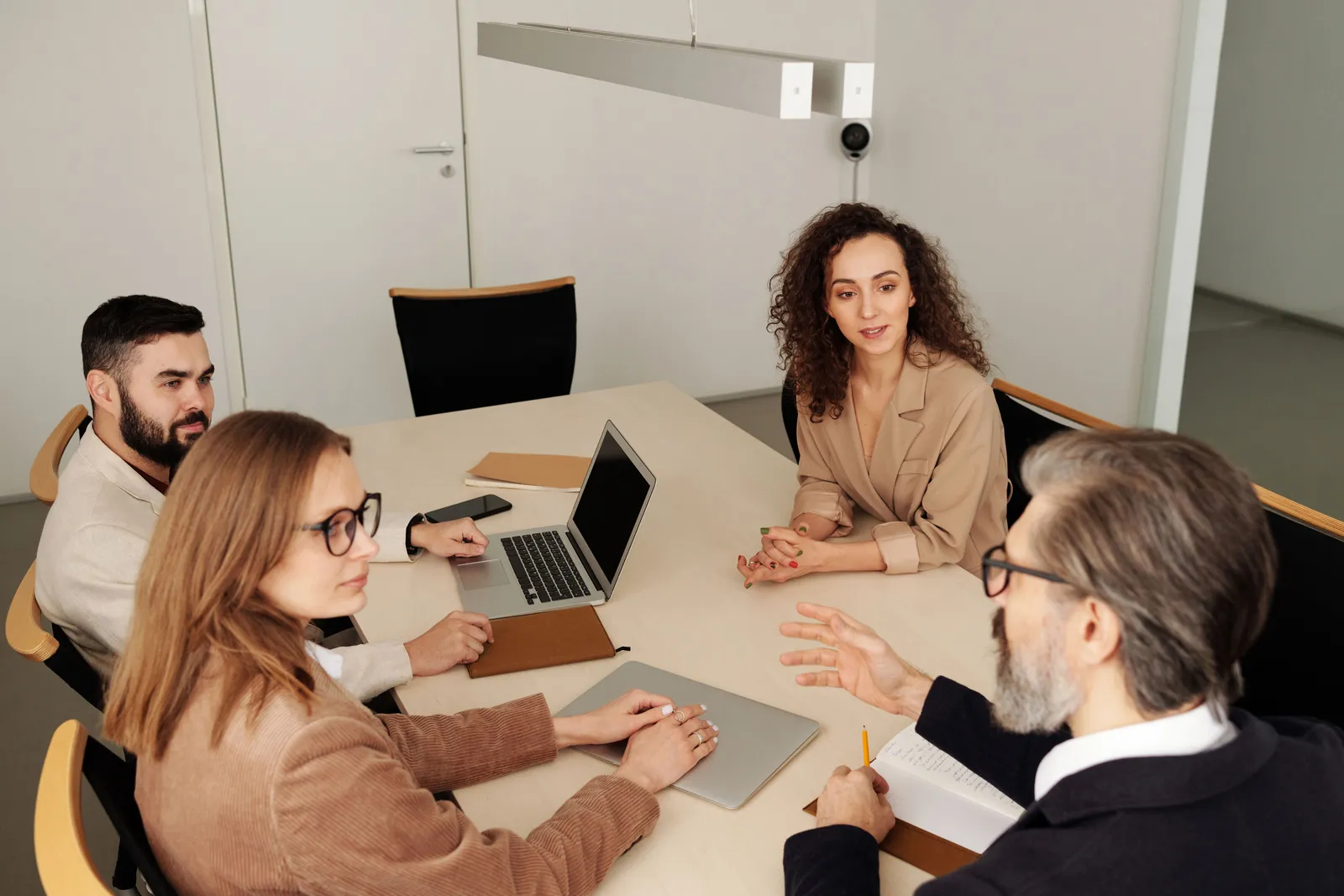 Professional team engaged in a meeting at a modern office table, discussing business strategies