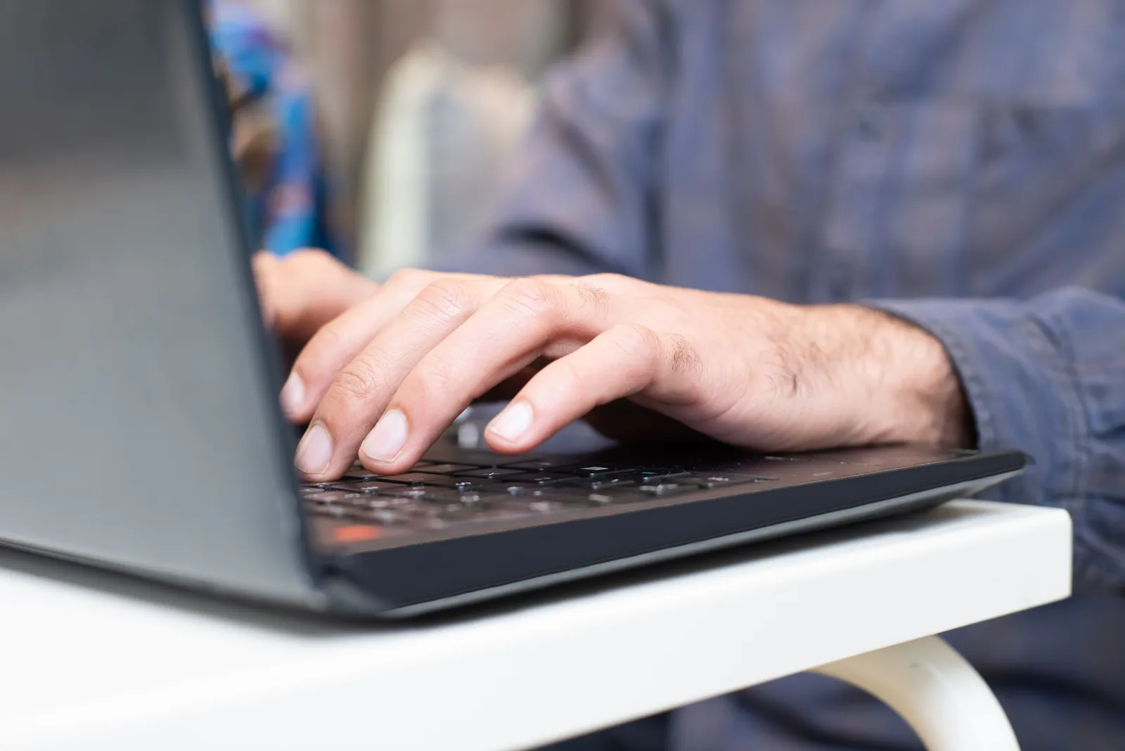 Close-up of hands typing on a laptop keyboard, focused and professional setting