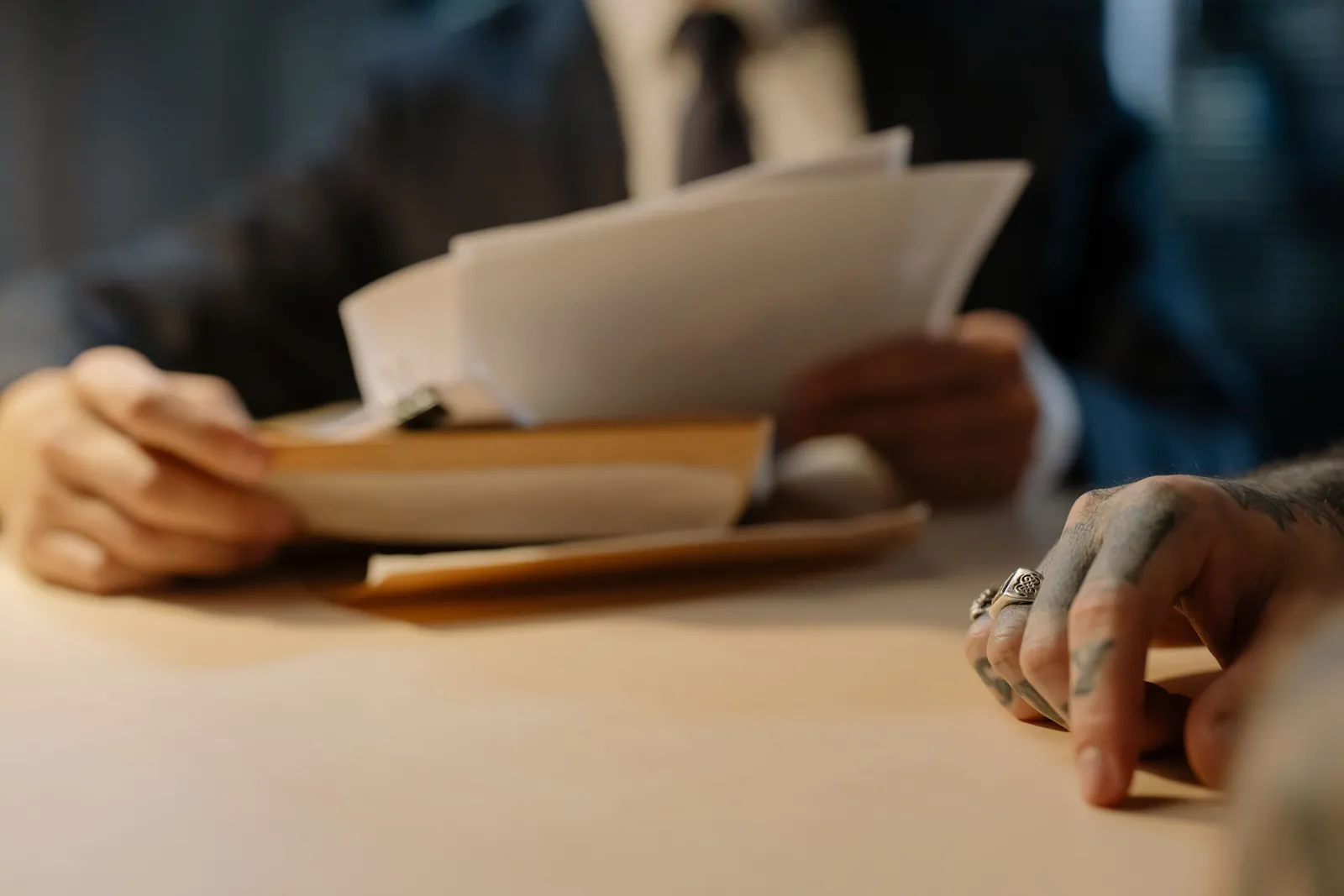 Close-up of business people reviewing documents at a desk, focused on hands and paperwork