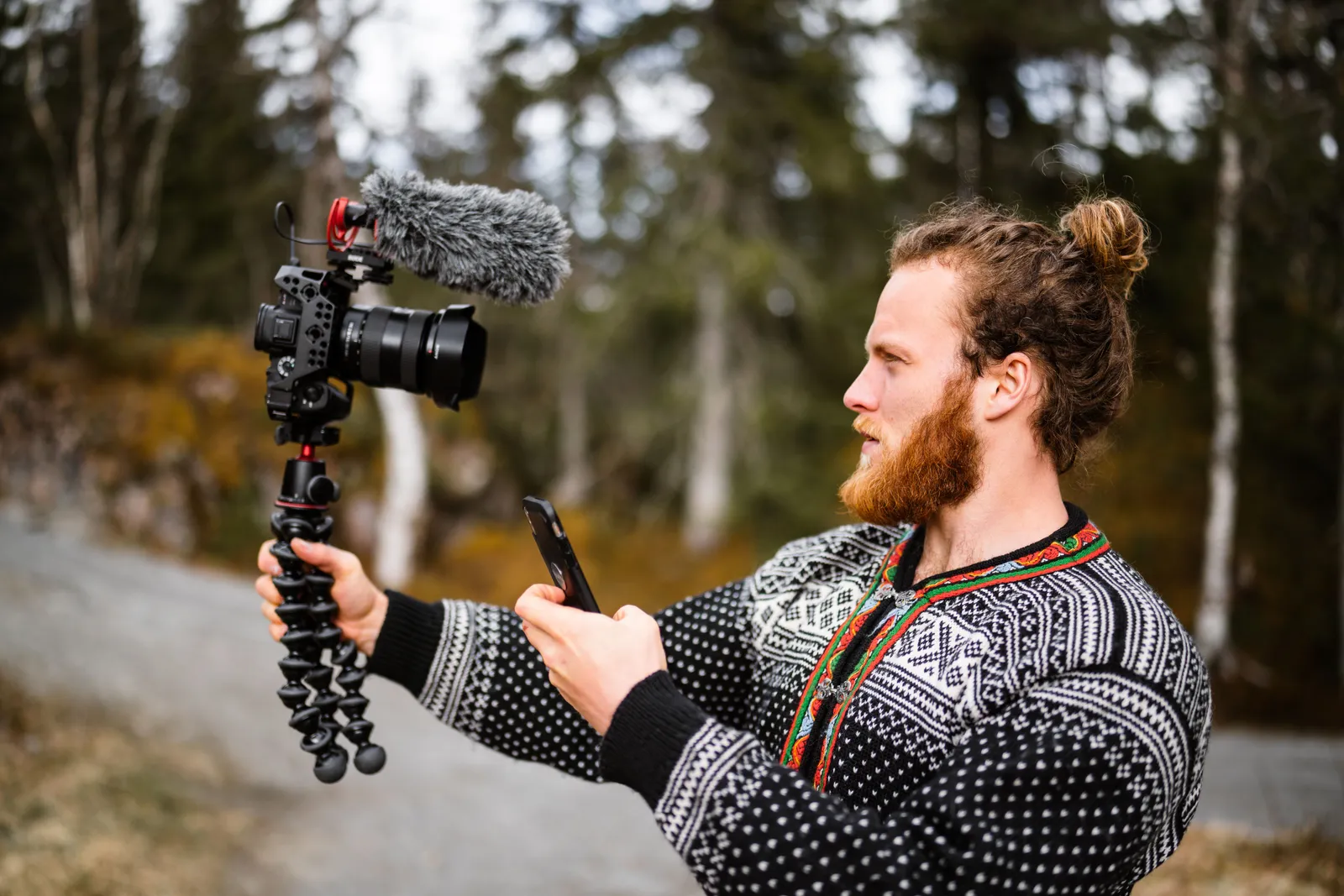 Bearded male vlogger in Norway filming outdoors with professional camera gear