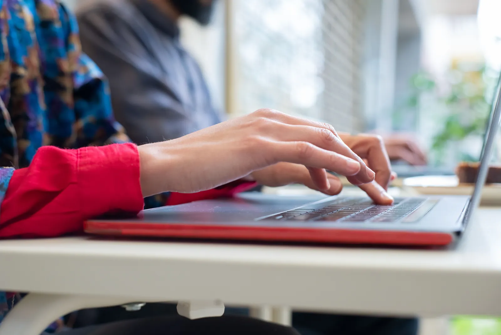 Person typing on a laptop indoors in Portugal, showing productivity and technology use