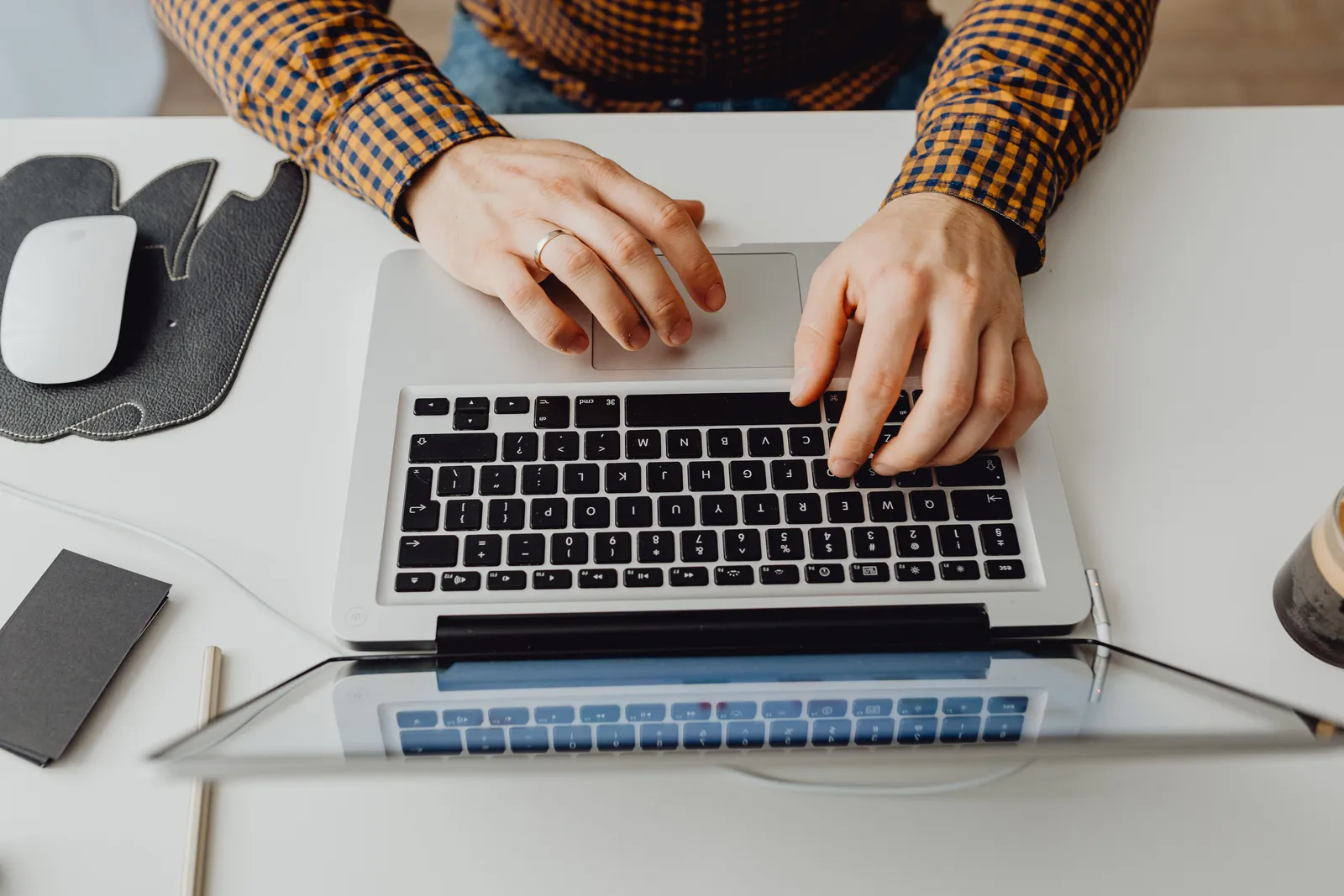 Hands typing on a laptop keyboard in a modern home office environment