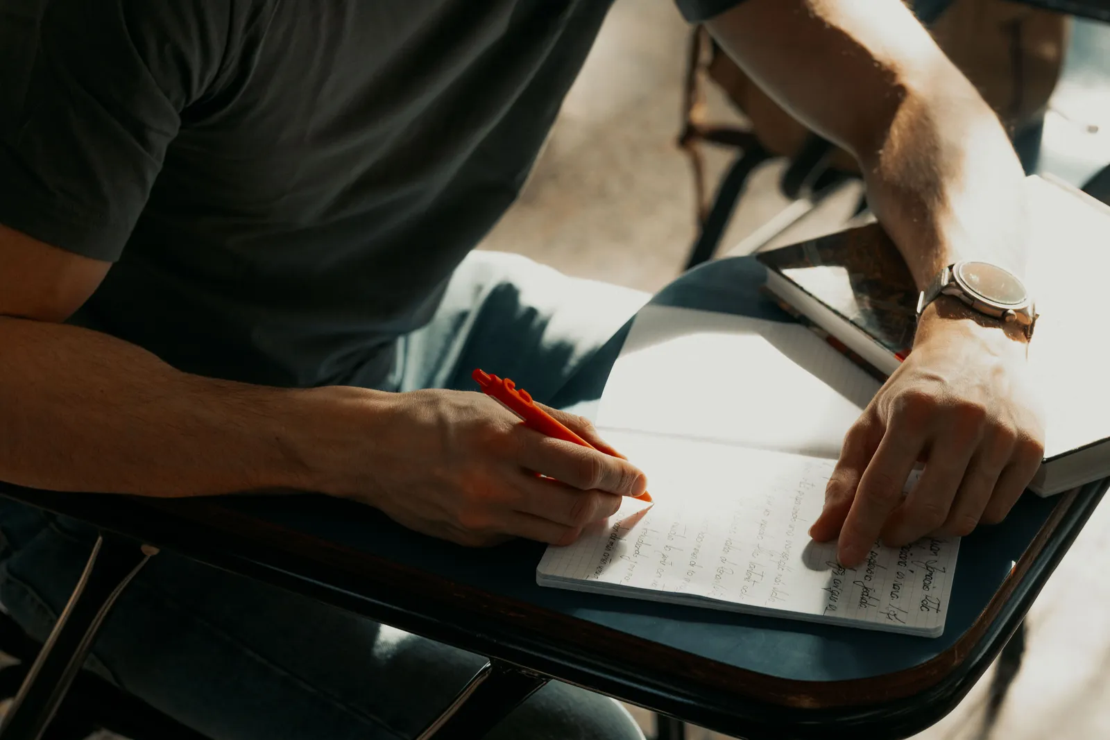 Focused student writing notes in a notebook during class