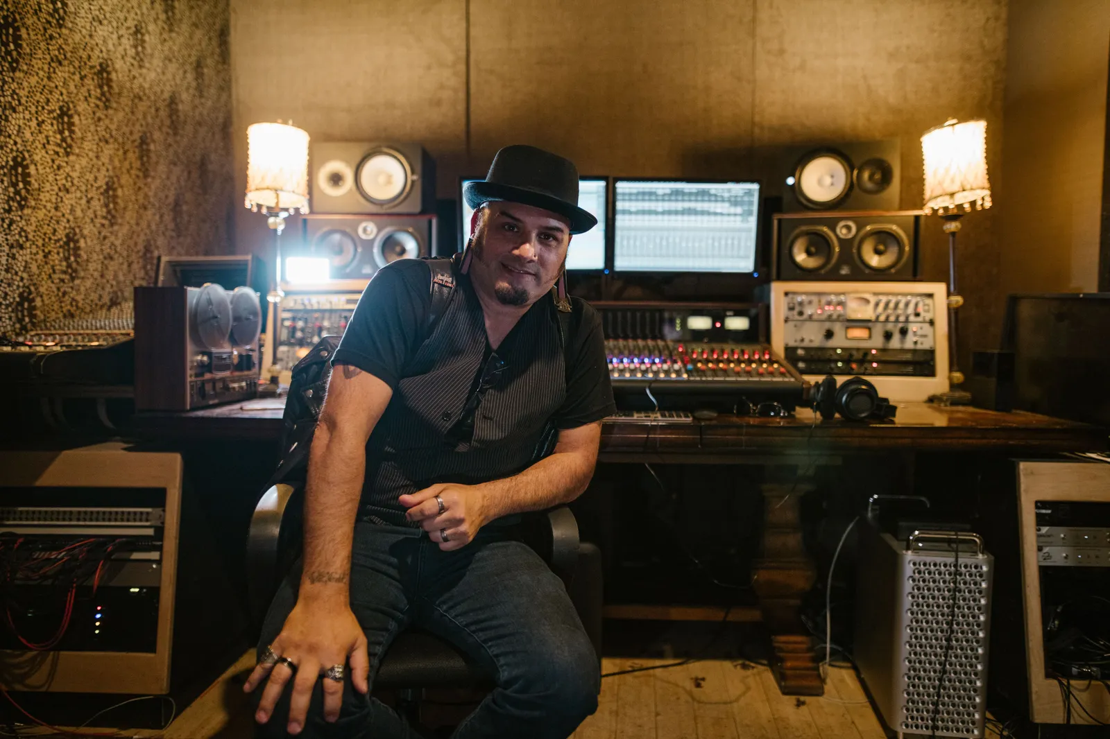 Music producer sitting in a modern recording studio with equipment and monitors