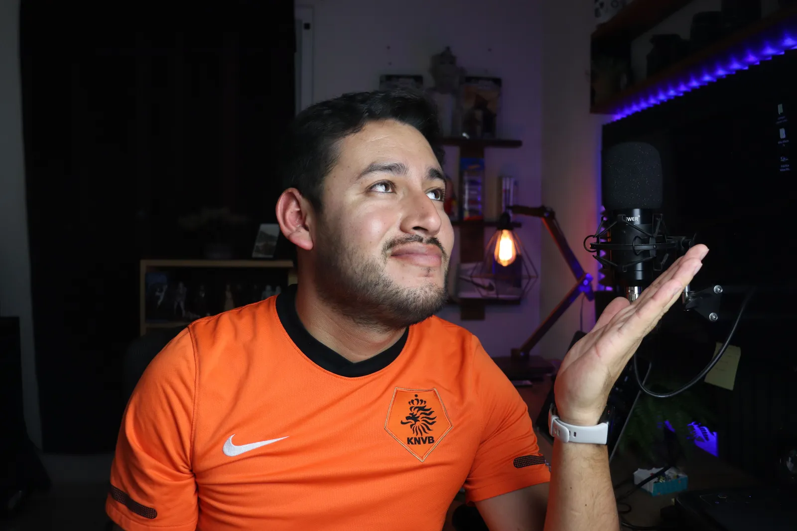 Portrait of a man in a home studio setting with a microphone, showcasing a thoughtful expression