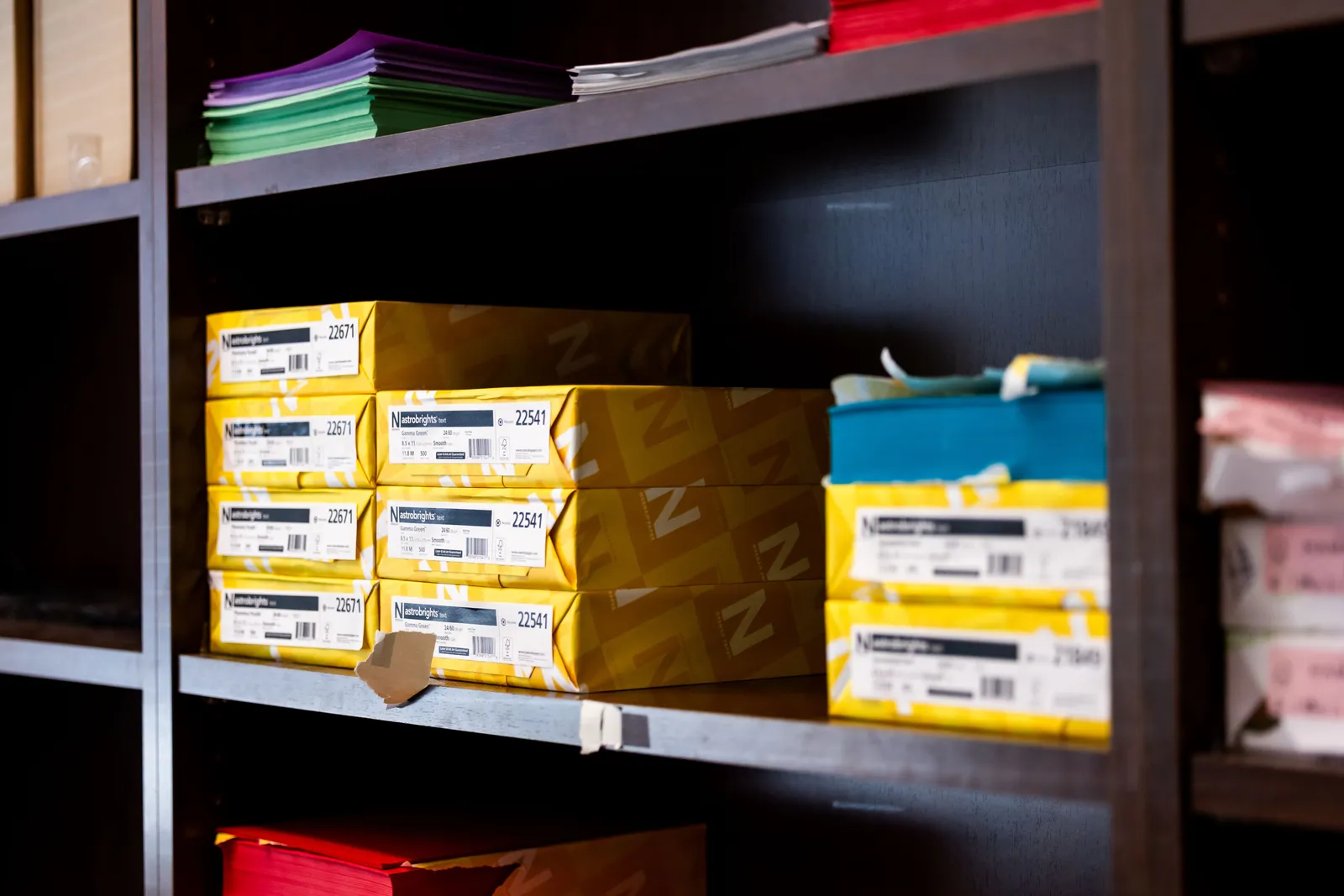 Stock photo of a shelf with colorful paper boxes for office supplies