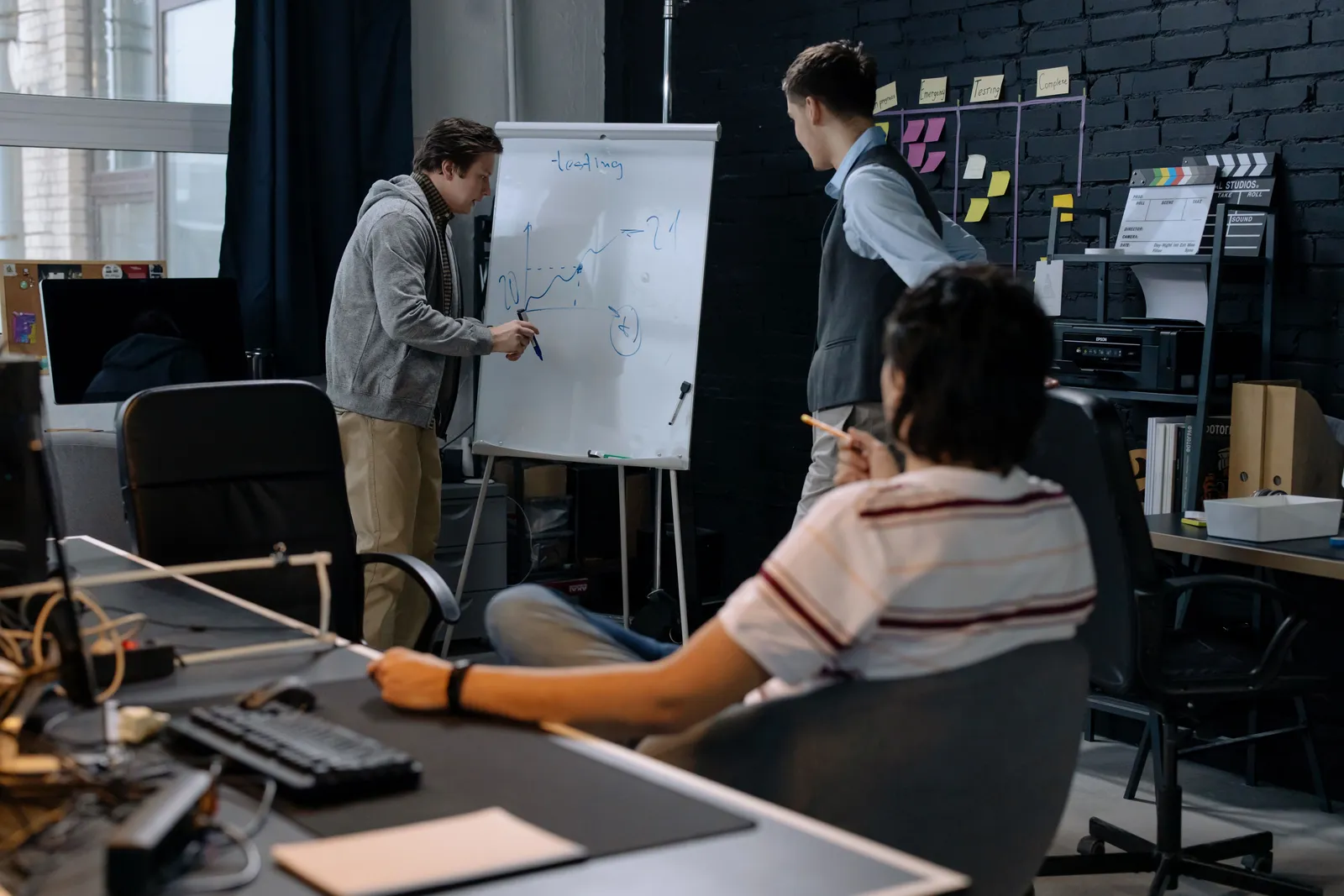 Business team in a modern office brainstorming ideas on a whiteboard. Engaged discussion and planning